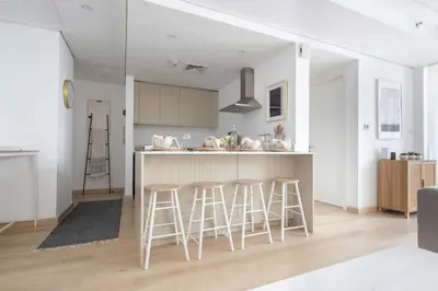 a kitchen with a counter and stools at Frank Porter - Goldcrest Views 2 in Dubai