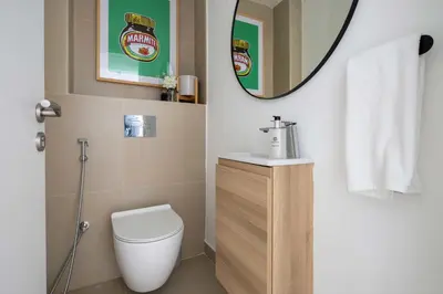 a bathroom with a toilet and a sink and a mirror at Frank Porter - Goldcrest Views 2 in Dubai