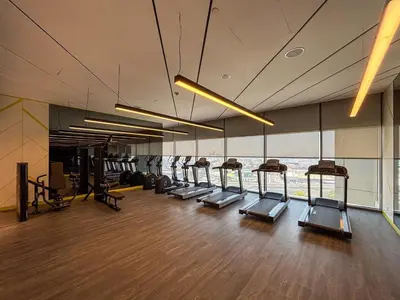 a gym with a row of treadmills in a room at Frank Porter - Aykon City Tower C in Dubai
