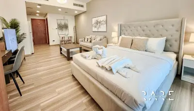 a bedroom with a large bed with towels on it at Rare Holiday Homes - Lake View - The Crescent Tower - Dubai Production City - R1611 in Dubai