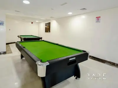 a pool table in a room with a green at Rare Holiday Homes - Lake View - The Crescent Tower - Dubai Production City - R1611 in Dubai