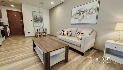 a living room with a couch and a table at Rare Holiday Homes - Lake View - The Crescent Tower - Dubai Production City - R1611 in Dubai