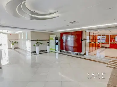 a lobby with red doors and a white tile floor at Rare Holiday Homes - Lake View - The Crescent Tower - Dubai Production City - R1611 in Dubai