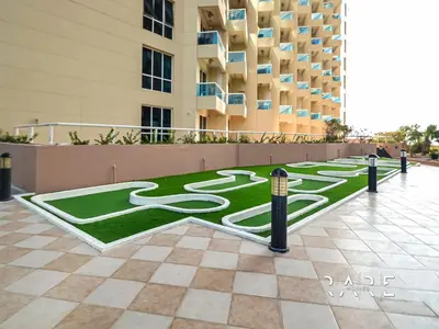 a grassy area in the middle of a building at Rare Holiday Homes - Lake View - The Crescent Tower - Dubai Production City - R1611 in Dubai