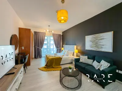 a living room with a couch and a bed at Rare Holiday Homes - The Crescent Tower - IMPZ - Dubai Production City - R705 in Dubai