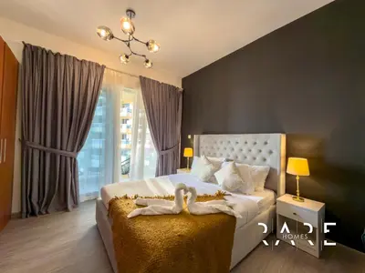 a bedroom with a bed with a large window at Rare Holiday Homes - The Crescent Tower - IMPZ - Dubai Production City - R705 in Dubai