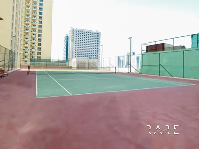 a tennis court on the roof of a building at Rare Holiday Homes - The Crescent Tower - IMPZ - Dubai Production City - R705 in Dubai