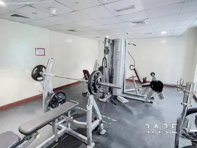a gym with two tread machines in a room at Rare Holiday Homes - The Crescent Tower - IMPZ - Dubai Production City - R705 in Dubai