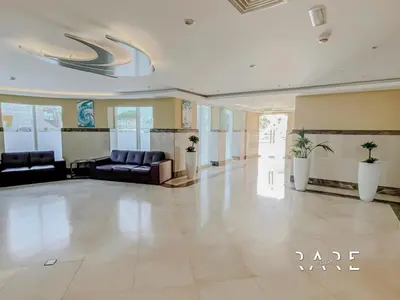 a lobby with couches and chairs in a building at Rare Holiday Homes - The Crescent Tower - IMPZ - Dubai Production City - R705 in Dubai