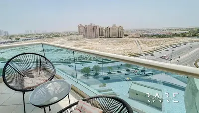a balcony with chairs and a view of a city at Rare Holiday Homes - Lake View - Near Me'aisem City Centre - The Crescent Tower A - Dubai Production City - R910 in Dubai