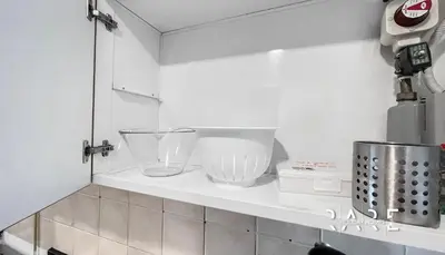 a kitchen counter with two bowls on a shelf at Rare Holiday Homes - Lake View - Near Me'aisem City Centre - The Crescent Tower A - Dubai Production City - R910 in Dubai
