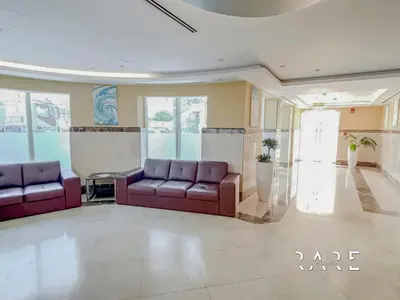 a lobby with two purple couches in a room at Rare Holiday Homes - Lake View - Near Me'aisem City Centre - The Crescent Tower A - Dubai Production City - R910 in Dubai