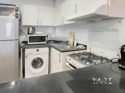 a kitchen with a stove and a washing machine at Rare Holiday Homes - Near The Lake - Lago Vista B - Dubai Production City - IMPZ - R2112 in Dubai