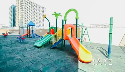a playground with colorful slides and swings at Rare Holiday Homes - Near The Lake - Lago Vista B - Dubai Production City - IMPZ - R2112 in Dubai