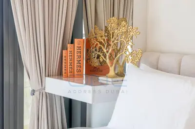 a shelf with books on it next to a bed at Designer 1BR on High Floor Downtown Vibes in Dubai