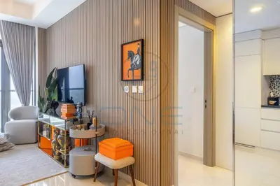 a living room with a television and a chair at Designer 1BR on High Floor Downtown Vibes in Dubai