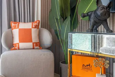 a living room with a chair and a plant at Designer 1BR on High Floor Downtown Vibes in Dubai