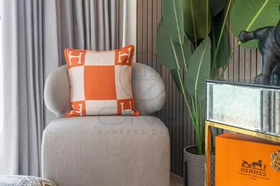a living room with a chair and a plant at Designer 1BR on High Floor Downtown Vibes in Dubai