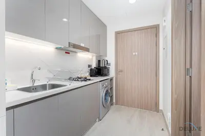 a kitchen with a sink and a washing machine at Comfortable Studio in Azizi Riviera 24, Al Merkadh by Deluxe Holiday Homes in Dubai