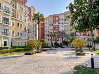 a park in front of a building with palm trees at Rare Holiday Homes - Mediterranean Cluster - Near Ibn Battuta Mall - Discovery Garden - Building# Med 49 - R514 in Dubai