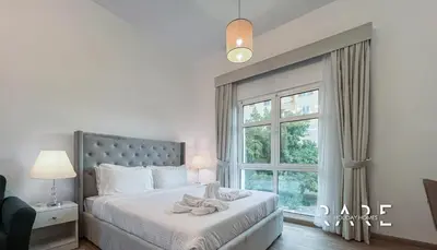 a bedroom with a bed with a large window at Rare Holiday Homes - Mediterranean Cluster - Near Ibn Battuta Mall - Discovery Garden - Building# Med 49 - R106 in Dubai