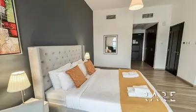 a bedroom with a large bed with white sheets and pillows at Rare Holiday Homes - Mediterranean Cluster - Near Ibn Battuta Mall - Discovery Garden - Building# Med 79 - R203 in Dubai