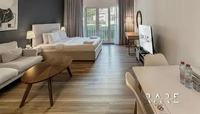 a hotel room with a bed and a living room at Rare Holiday Homes - Mediterranean Cluster - Near Ibn Battuta Mall - Discovery Garden - Building# Med 100 - RG13 in Dubai