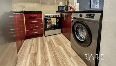 a laundry room with a washer and a wooden floor at Rare Holiday Homes - Mediterranean Cluster - Near Ibn Battuta Mall - Discovery Garden - Building# Med 100 - RG13 in Dubai