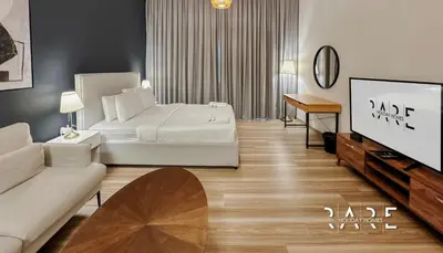 a living room with a bed and a flat screen tv at Rare Holiday Homes - Mediterranean Cluster - Near Ibn Battuta Mall - Discovery Garden - Building# Med 100 - RG13 in Dubai