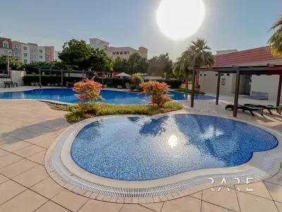 a large swimming pool in the middle of a courtyard at Rare Holiday Homes - Mediterranean Cluster - Near Ibn Battuta Mall - Discovery Garden - Building# Med 100 - RG13 in Dubai