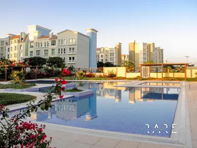 a large swimming pool with buildings in the background at Rare Holiday Homes - Mediterranean Cluster - Near Ibn Battuta Mall - Discovery Garden - Building# Med 100 - RG13 in Dubai
