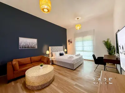 a living room with a bed and a couch at Rare Holiday Homes - Mediterranean Cluster - Near Metro - Discovery Garden - Building# Med 103 - RG07 in Dubai