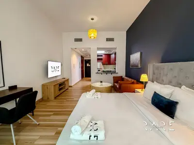 a bedroom with a large bed and a living room at Rare Holiday Homes - Mediterranean Cluster - Near Metro - Discovery Garden - Building# Med 103 - RG07 in Dubai