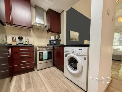a kitchen with a washer and a dishwasher at Rare Holiday Homes - Mediterranean Cluster - Near Metro - Discovery Garden - Building# Med 103 - RG07 in Dubai