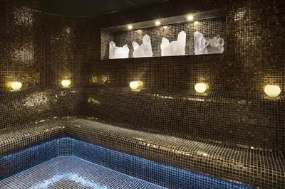 a bathroom with a swimming pool with white towels and lights at Downtown Studio - Cour Jardin in Dubai