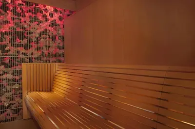 a wooden bench in a room with a red wall at Downtown Studio - Cour Jardin in Dubai