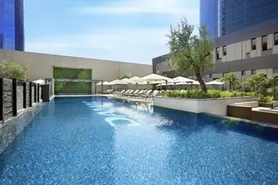 a swimming pool with blue water in a building at Downtown Studio - Cour Jardin in Dubai
