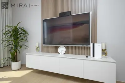 a tv on top of a white cabinet in a room at Mira Holiday Homes - Luxury 2 bedroom in Le Pont in Dubai