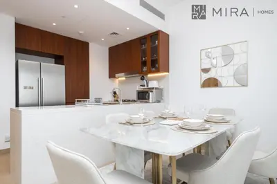 a kitchen with a white table and chairs at Mira Holiday Homes - Luxury 2 bedroom in Le Pont in Dubai