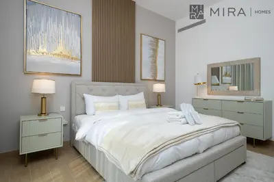 a bedroom with a large bed and two night stands at Mira Holiday Homes - Luxury 2 bedroom in Le Pont in Dubai