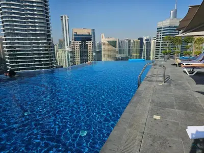 a large swimming pool on the roof of a building at Waterfront Living 2BR Apartment in Marina Star, Dubai Marina by Deluxe Holiday Homes in Dubai