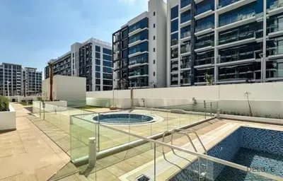 a swimming pool in the middle of a building at Luxurious 2BR Apartment in Azizi Riviera 18, Al Merkadh by Deluxe Holiday Homes in Dubai