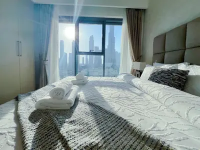 a bedroom with two towels on a bed with a window at 2BR Stunning Full Burj Khalifa View in Dubai