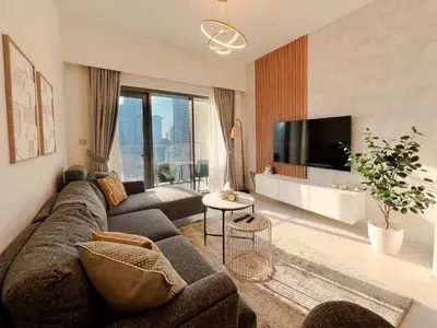 a living room with a couch and a tv at 2BR Stunning Full Burj Khalifa View in Dubai