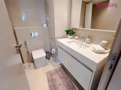 a white bathroom with a sink and a mirror at 2BR Stunning Full Burj Khalifa View in Dubai
