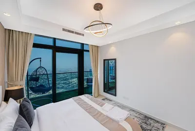 a bedroom with a bed and a large window at 3 King Beds - 7mins to Dubai Mall - High Floor Sun Set and Sea View in Dubai