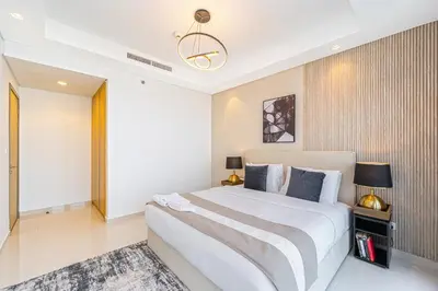 a bedroom with a large white bed and a chandelier at 3 King Beds - 7mins to Dubai Mall - High Floor Sun Set and Sea View in Dubai