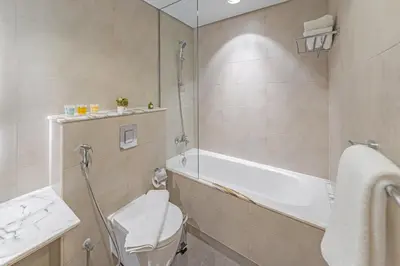 a bathroom with a tub and a toilet and a sink at 3 King Beds - 7mins to Dubai Mall - High Floor Sun Set and Sea View in Dubai