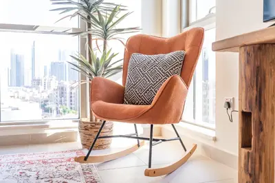 a chair with a pillow in a room with a window at Boulevard 2 BR- Burj Khalifa-Dubai Mall- pool-Gym in Dubai