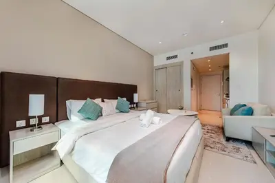 a large white bedroom with a large bed and a couch at Popular Seven Palm Apartments in Dubai